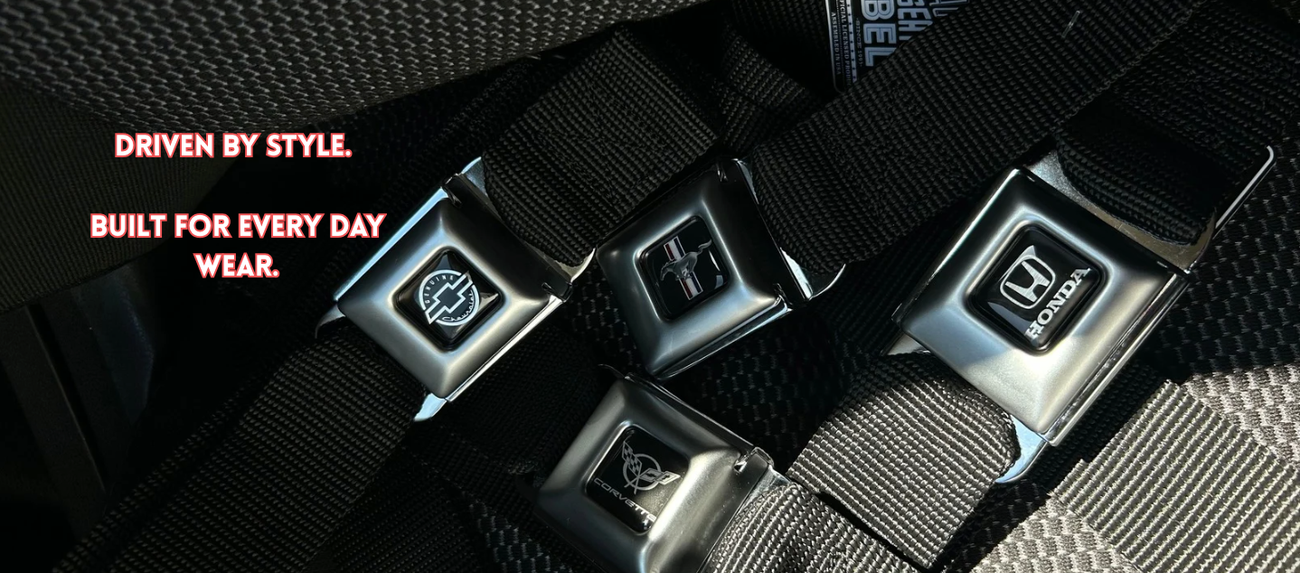 Automotive inspired seatbelt belts by the brand 'buckle-down' featuring honda, chevy, corvette, mustang on a car seat.