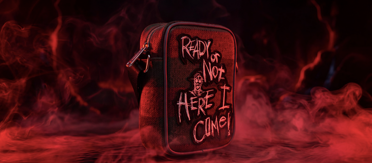 red smokey scenery with a crossbody bag that says "ready or not here i come!" inspired by the movie friday the 13th by the brand 'buckle-down'